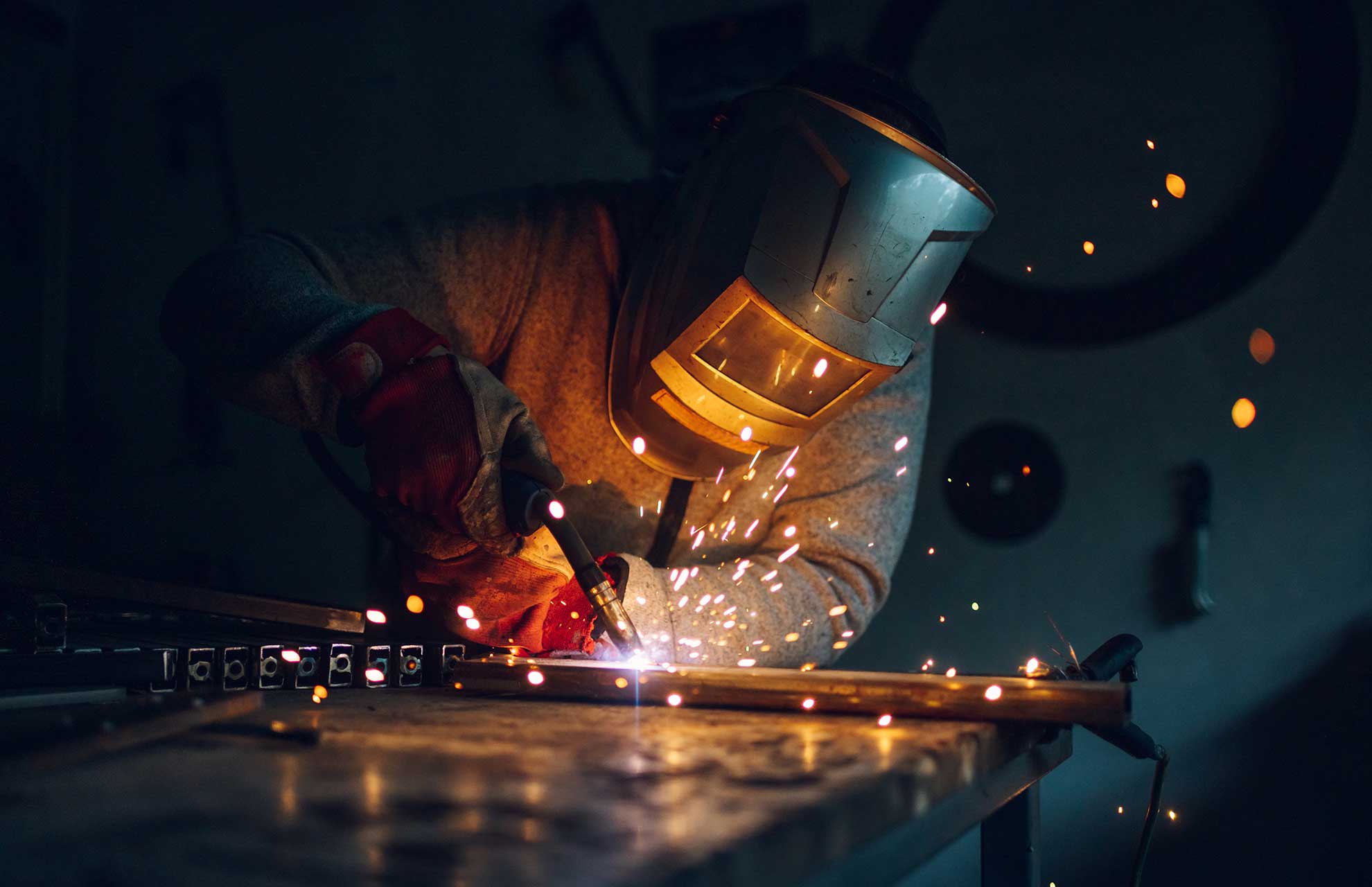 man worker welding metal with welding machine