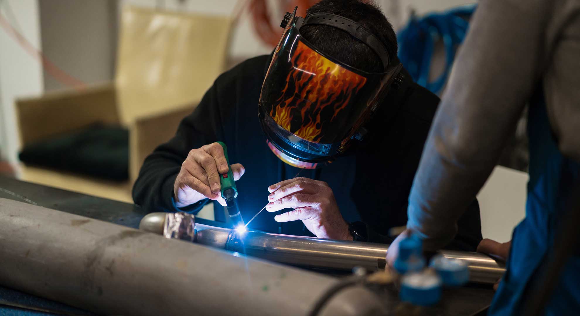 man working with argon welding machine in a garage